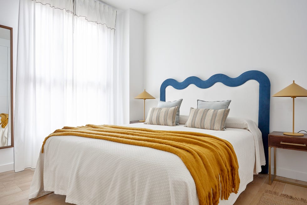 dormitorio de estilo mid century con cabecero con diseño de ondas tapizado en blanco y azul