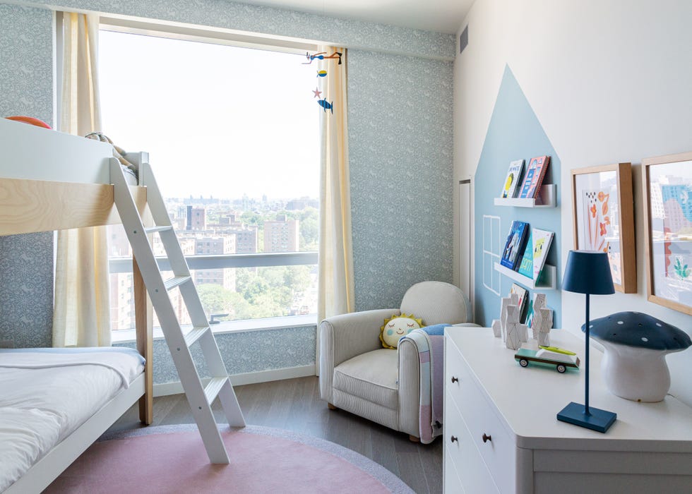 habitación infantil con dos literas y papel pintado azul con motivos de flora y fauna