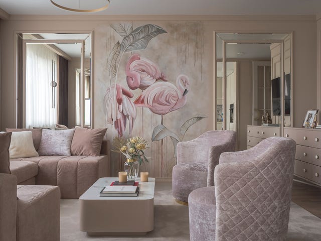 salón rosa con butacas y sofá de terciopelo y mural con pelicanos en la pared