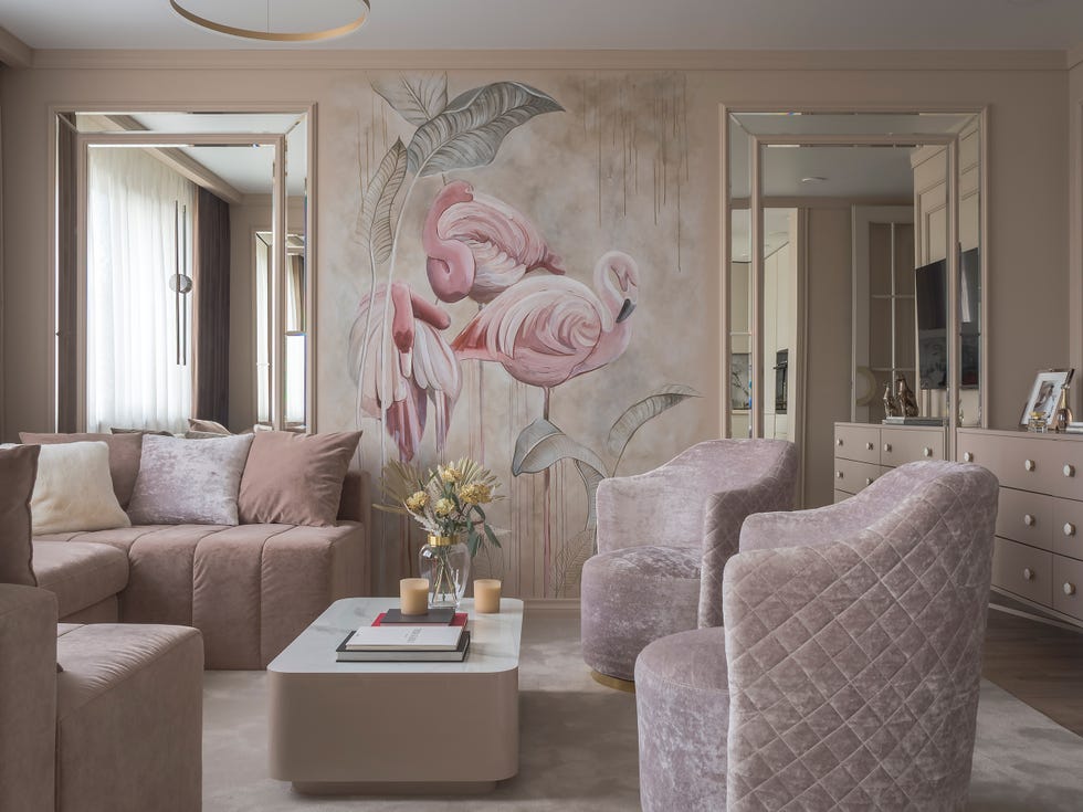 salón rosa con butacas y sofá de terciopelo y mural con pelicanos en la pared