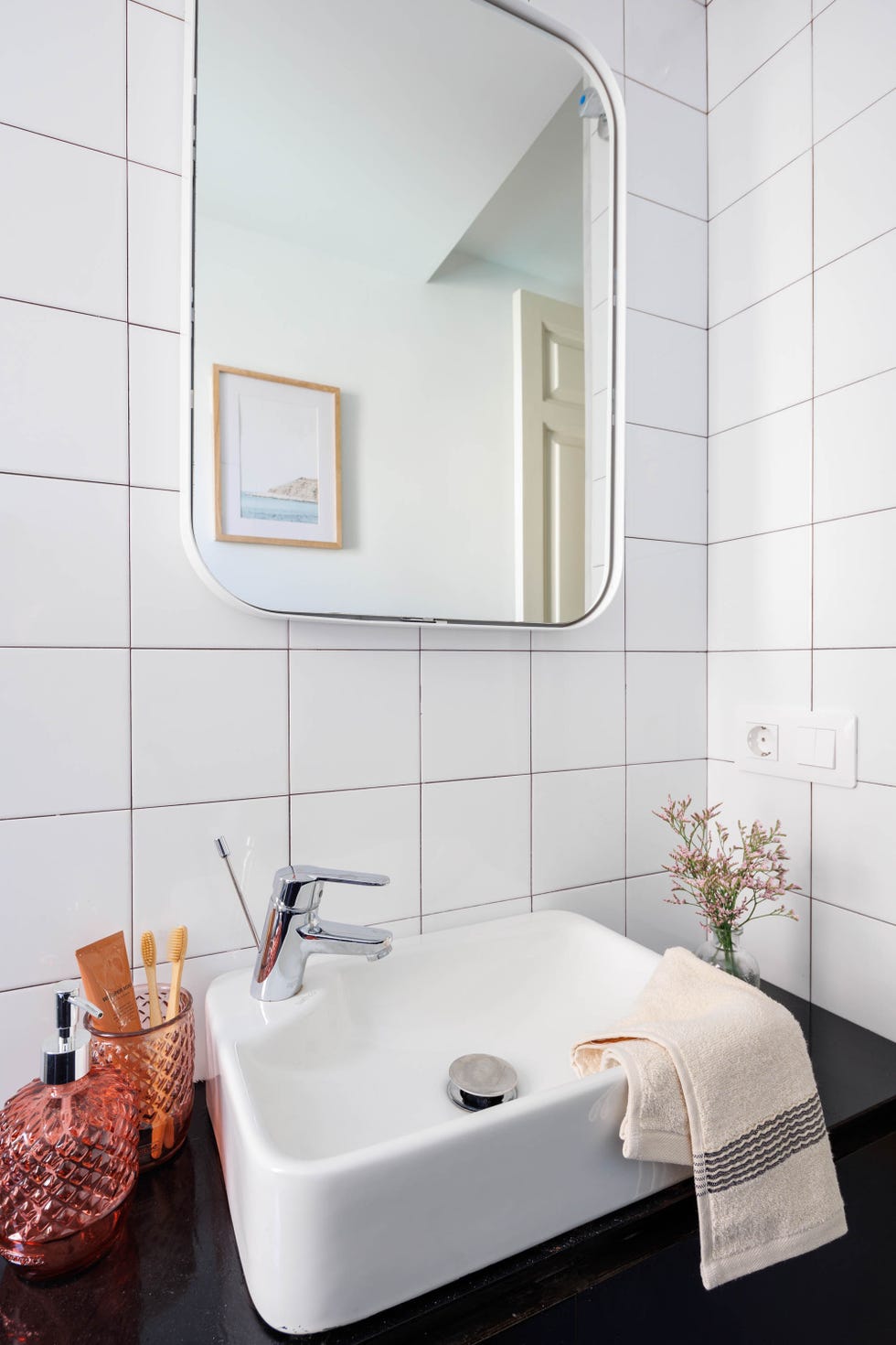 baño con azulejos cuadrados blancos y lavabo exento