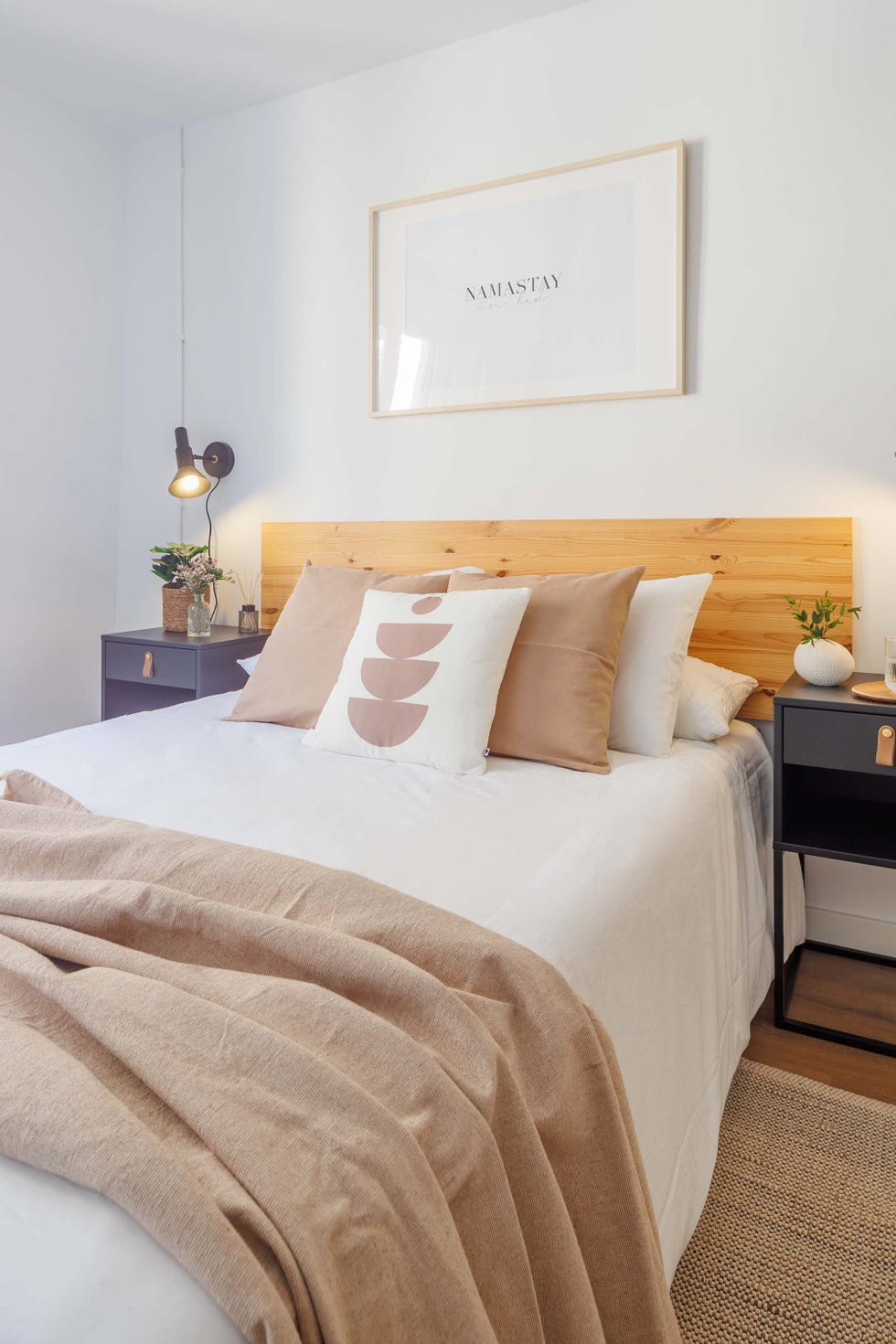 dormitorio con cama y cabecero de madera y mesitas negras