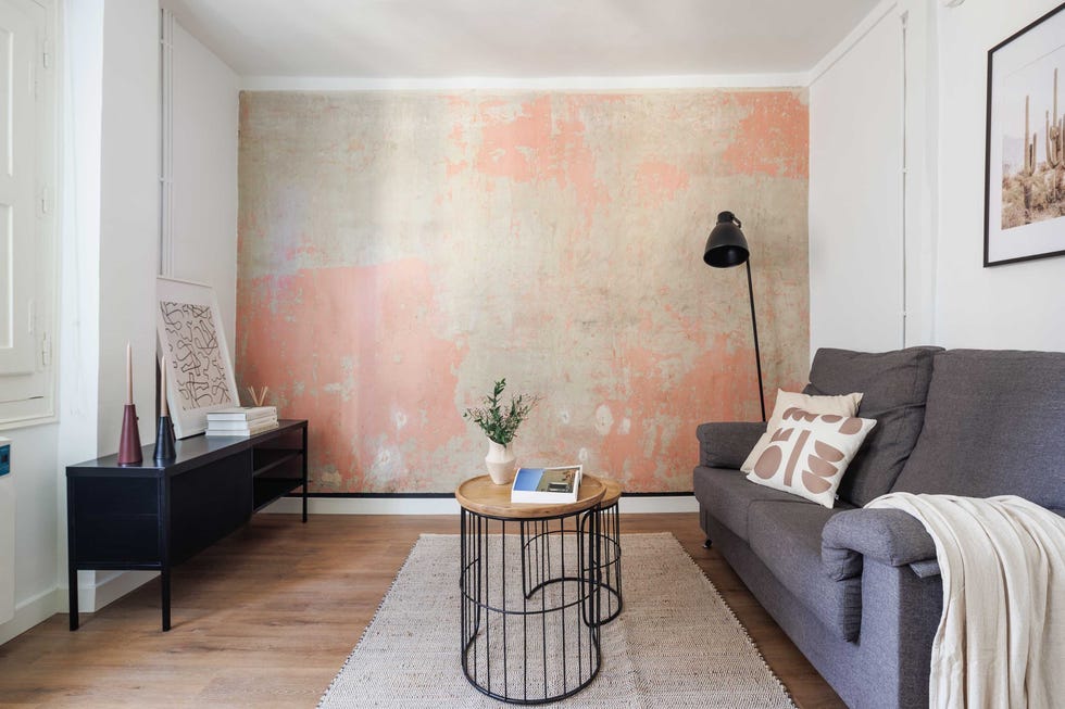 salón industrial con sofá gris y pared recuperada
