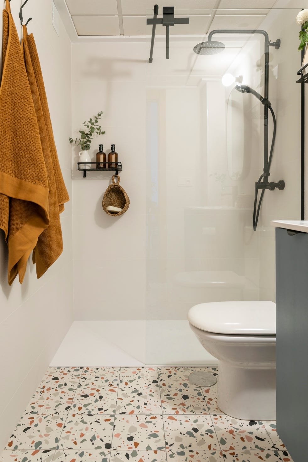 baño con ducha de obra y suelo de terrazo