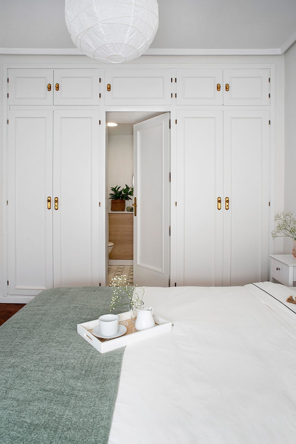dormitorio con armarios lacados en blanco y baño en suite