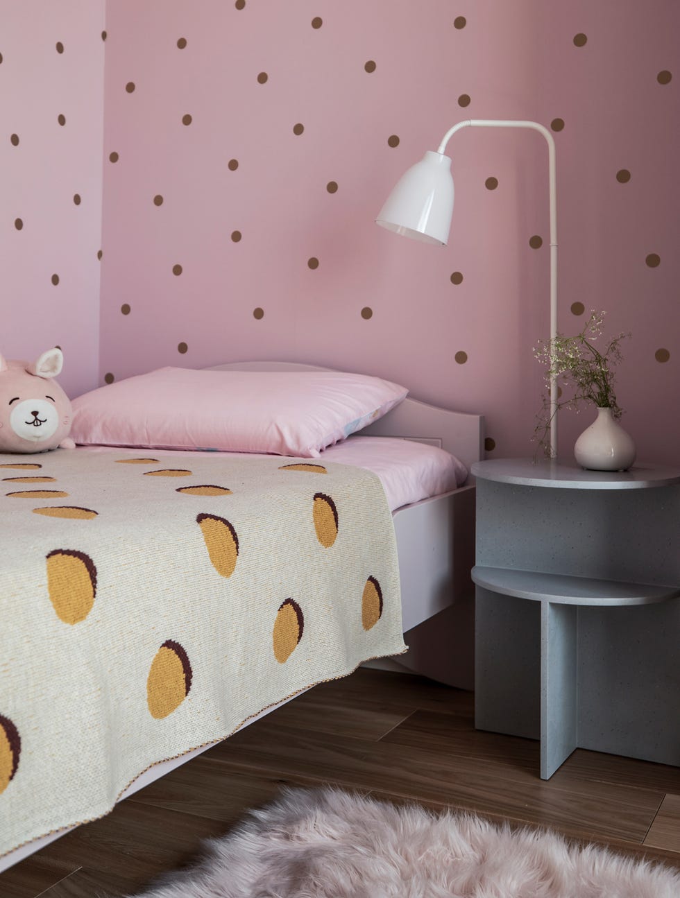 Dormitorio infantil decorado con papel pintado rosa y lunares dorados
