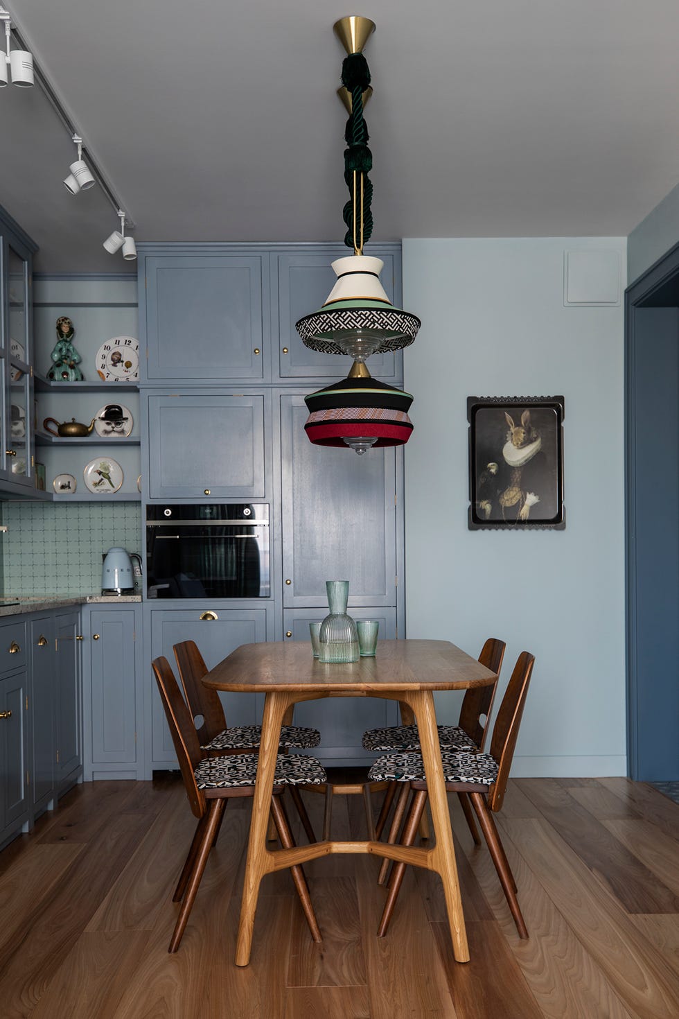 Cocina decorada en azul grisáceo con mesa de comedor de madera hecha a mano