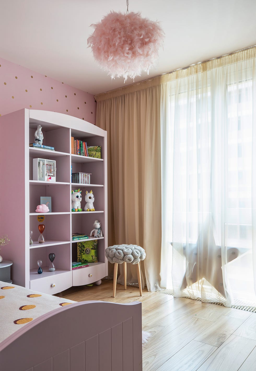 Dormitorio infantil decorado en color rosa con estantería abierta