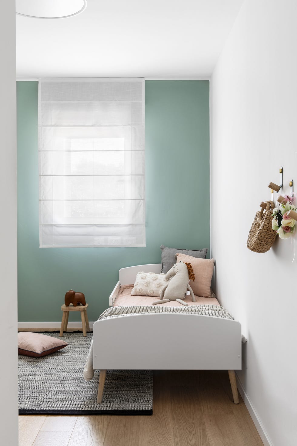habitación infantil de diseño nórdico con pared verde