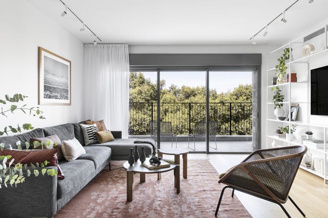 salón moderno con sofá con chaise longue y estantería metálica blanca