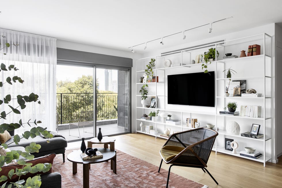 salón moderno con sofá con chaise longue y estantería metálica blanca