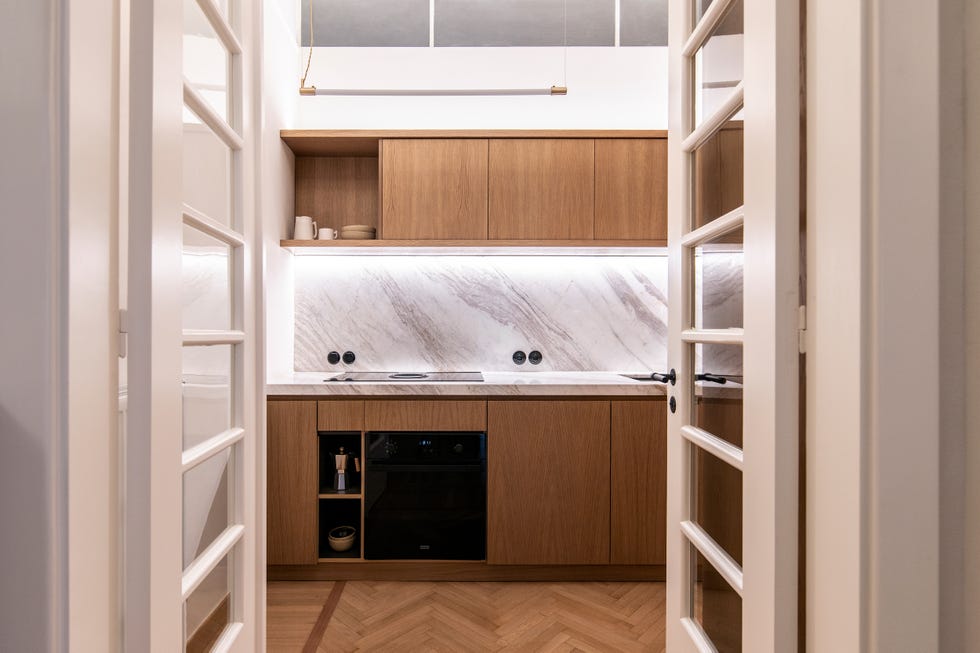 cocina con muebles de madera y encimera y frente de mármol