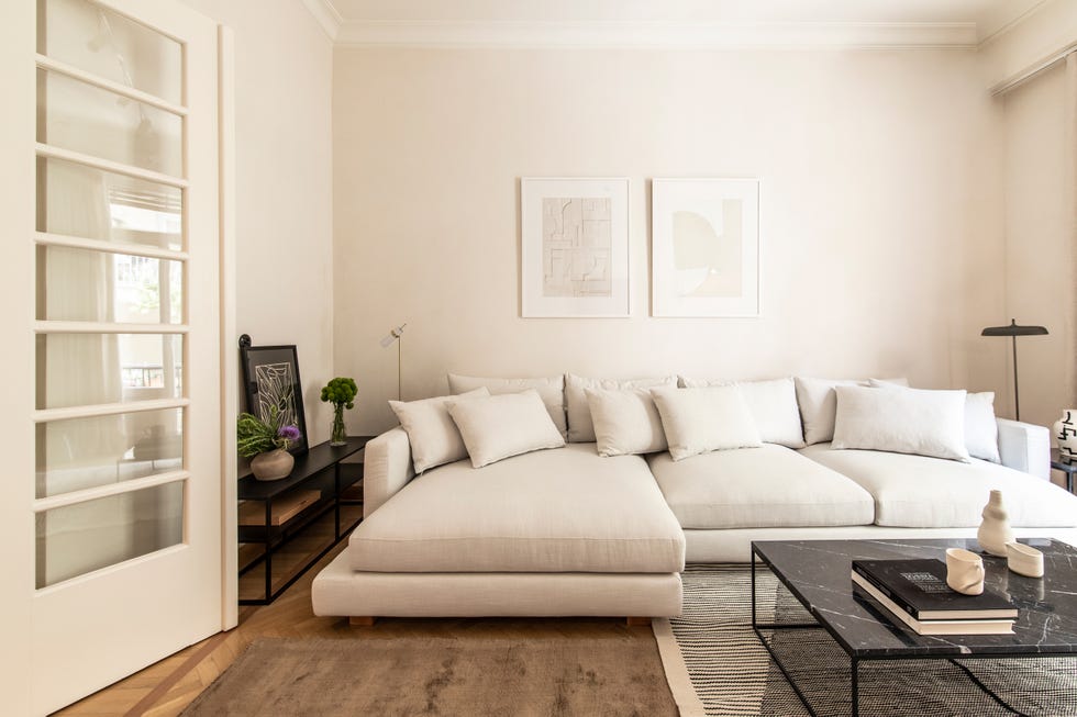 salón con sofá blanco con chaise longue y mesa de centro de mármol negro