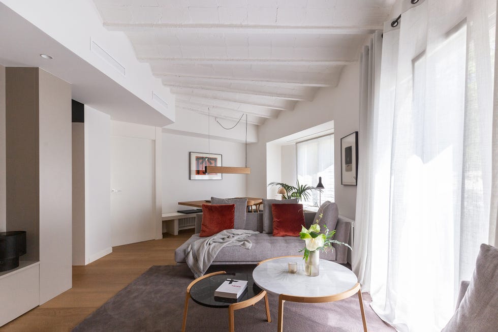 salón comedor moderno con sofá gris y mesas de centro tipo nido