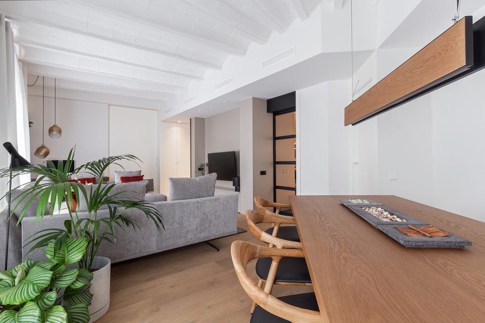 salón comedor moderno con sofás grises y mesa de comedor de madera