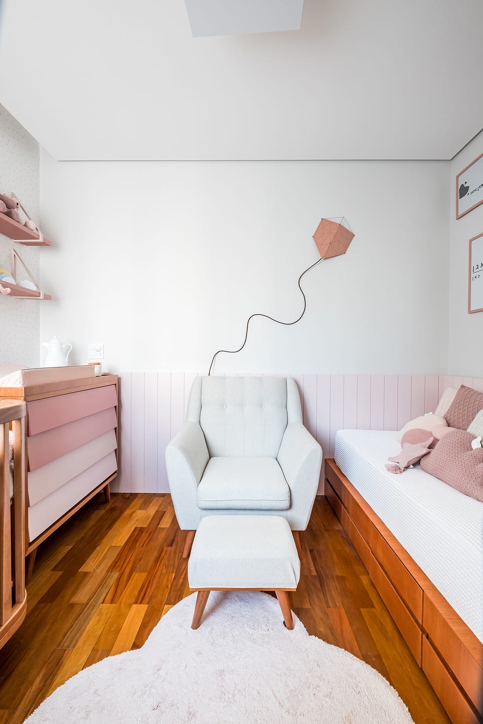 habitación de bebé con cuna, cambiador, butaca, reposapiés y cama