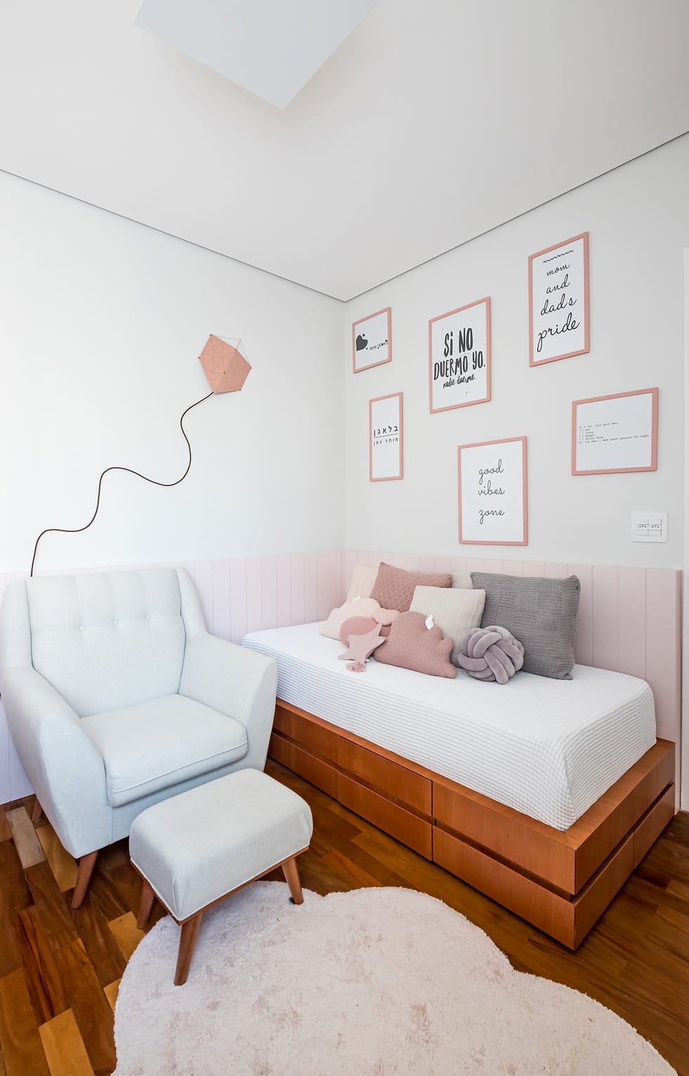 cama infantil con estructura de madera junto a butaca con reposapiés