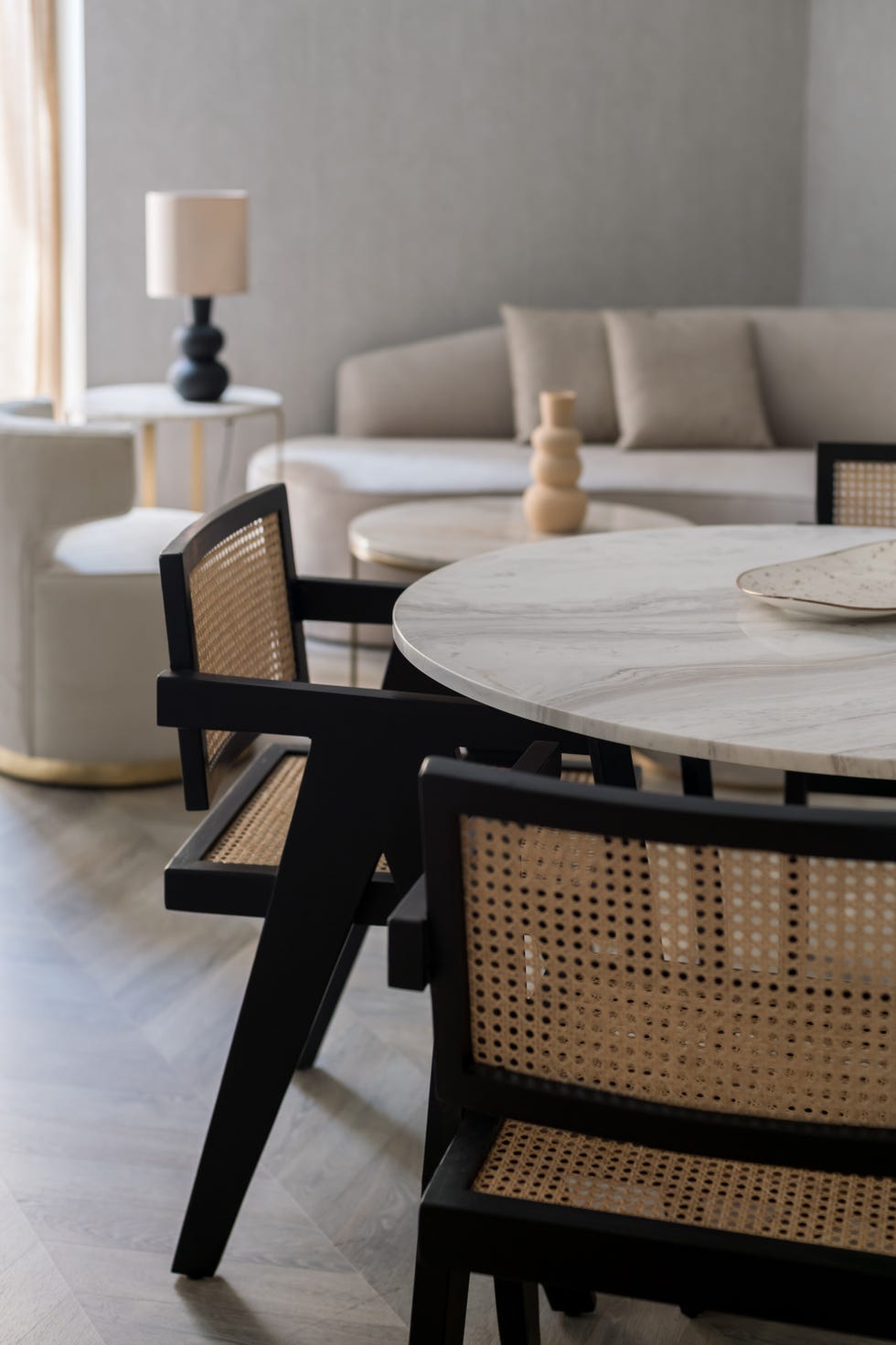 mesa de comedor redonda de mármol y sillas vintage de madera y rejilla de ratán