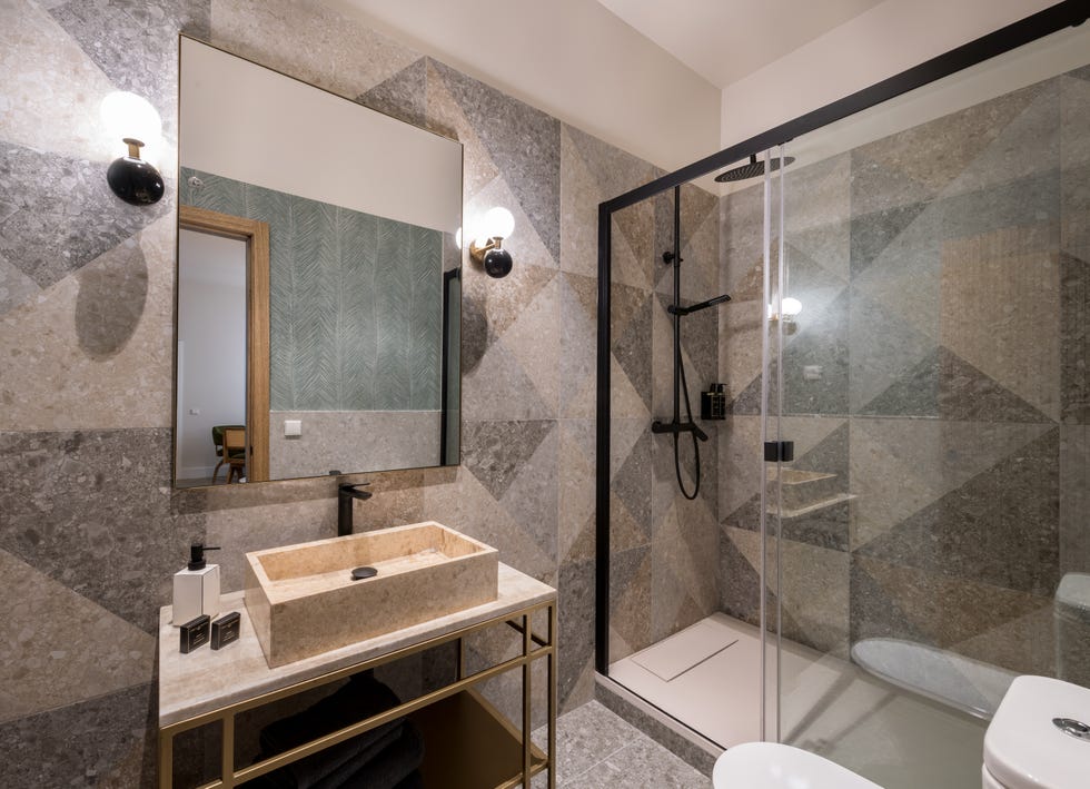 baño con ducha y azulejos geométricos en tonos grises