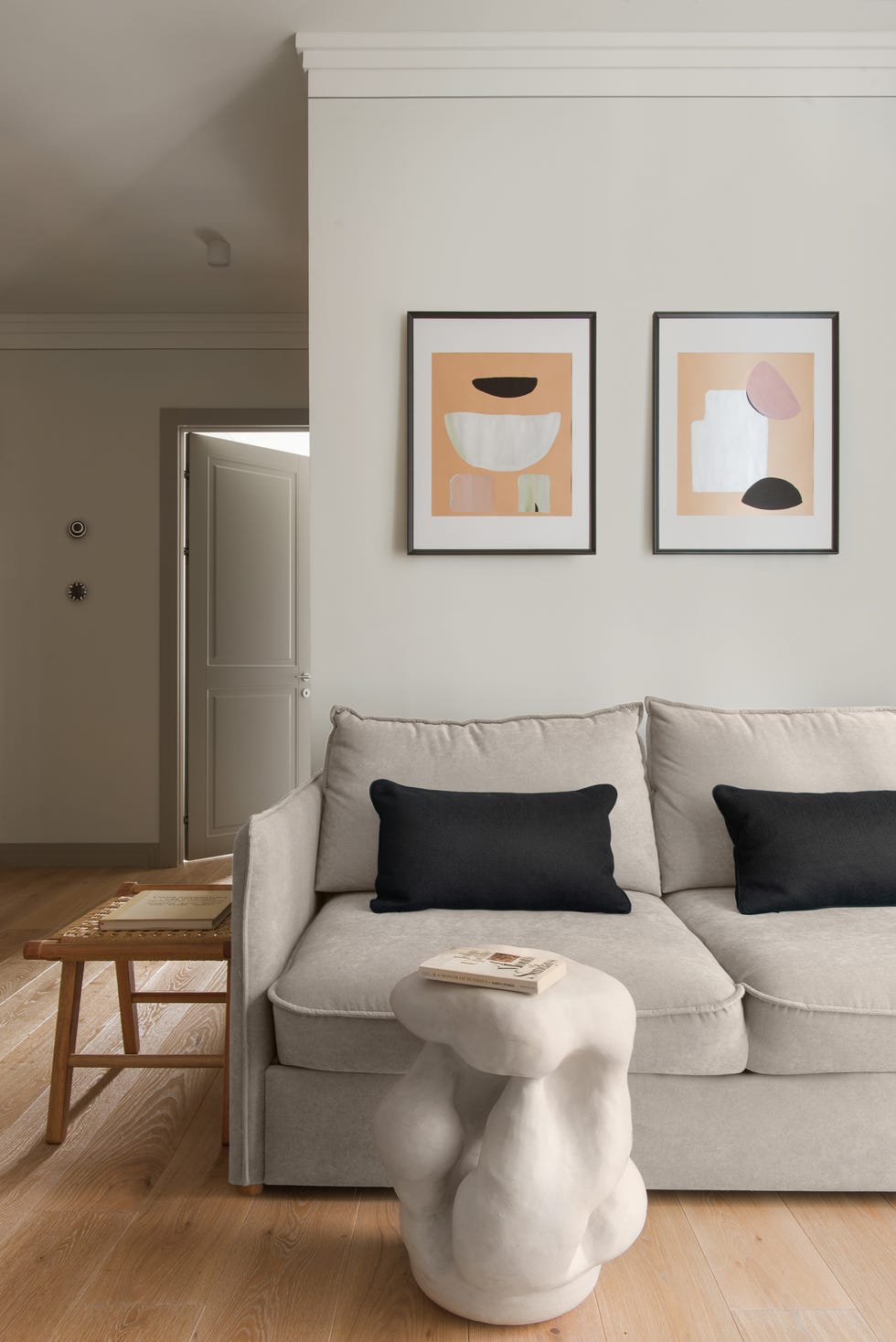 salón moderno con sofá gris y mesa auxiliar escultural