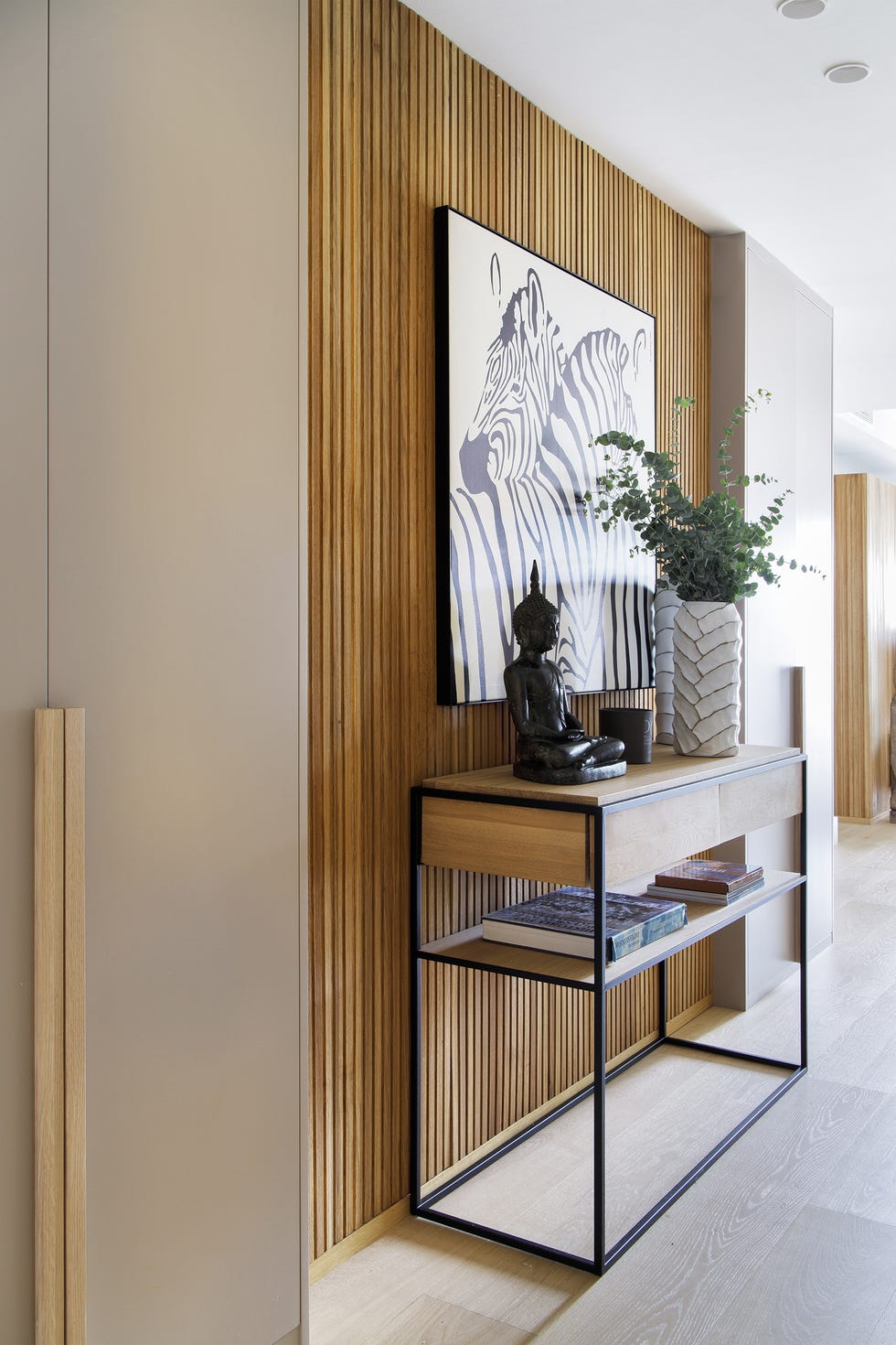 pared con listones de madera y consola de madera y estructura de metal en el recibidor