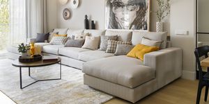 sofá con chaiselongue beige moderno y cuadro con la ilustración de una mujer