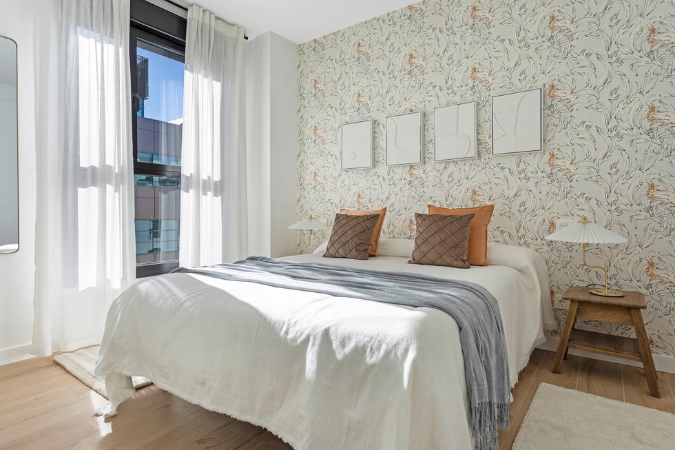dormitorio con papel pintado con motivos florales y mesillas de madera