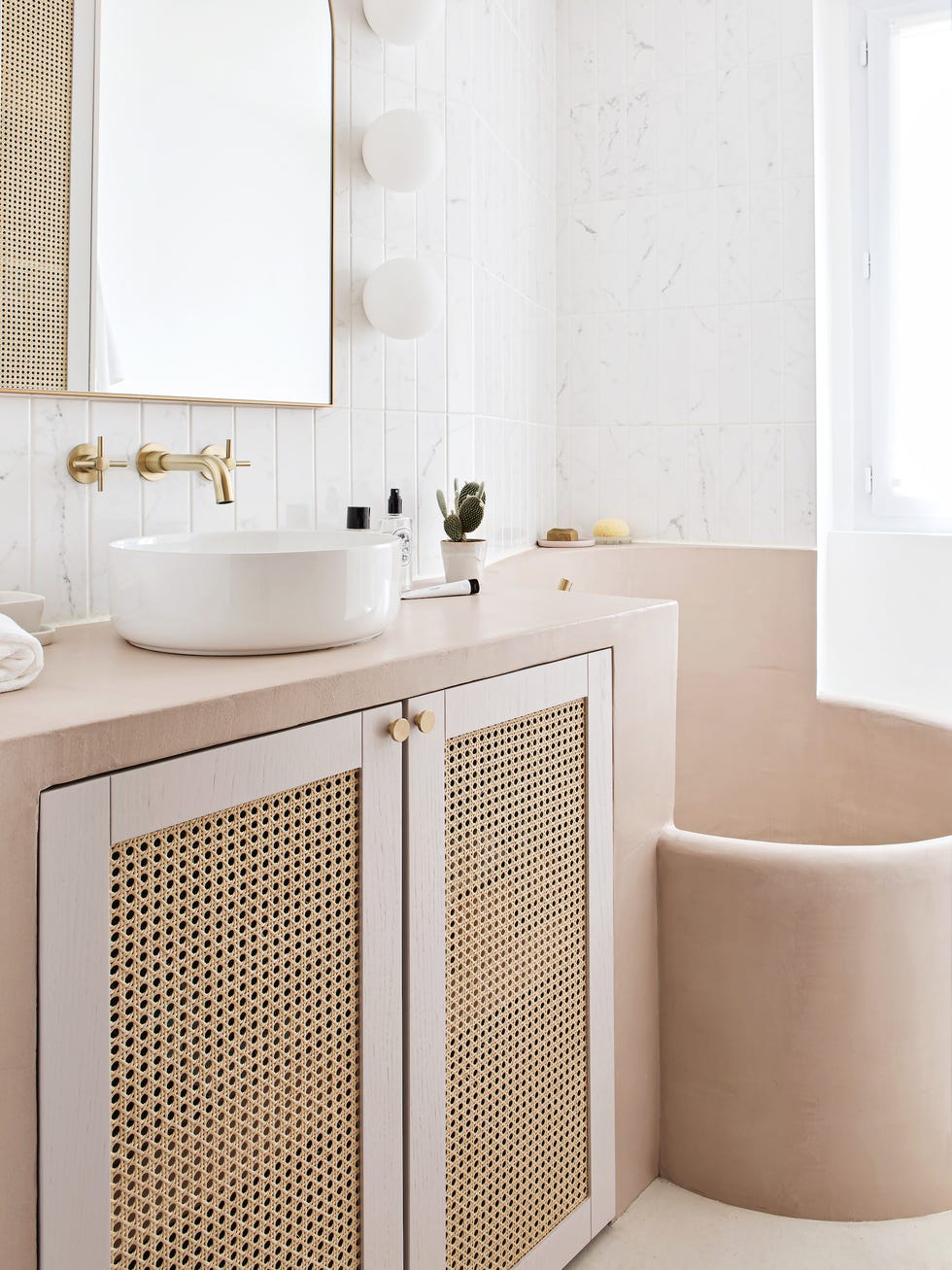 baño de diseño vintage en blanco y rosa empolvado con puertas de cannage