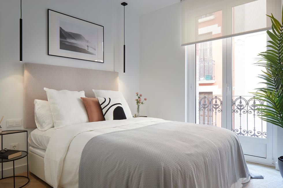 dormitorio de diseño moderno con cabecero beige y lámparas suspendidas