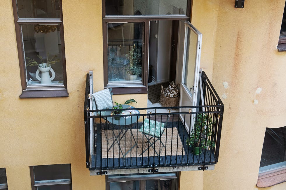 balcón con mesa y sillas plegables