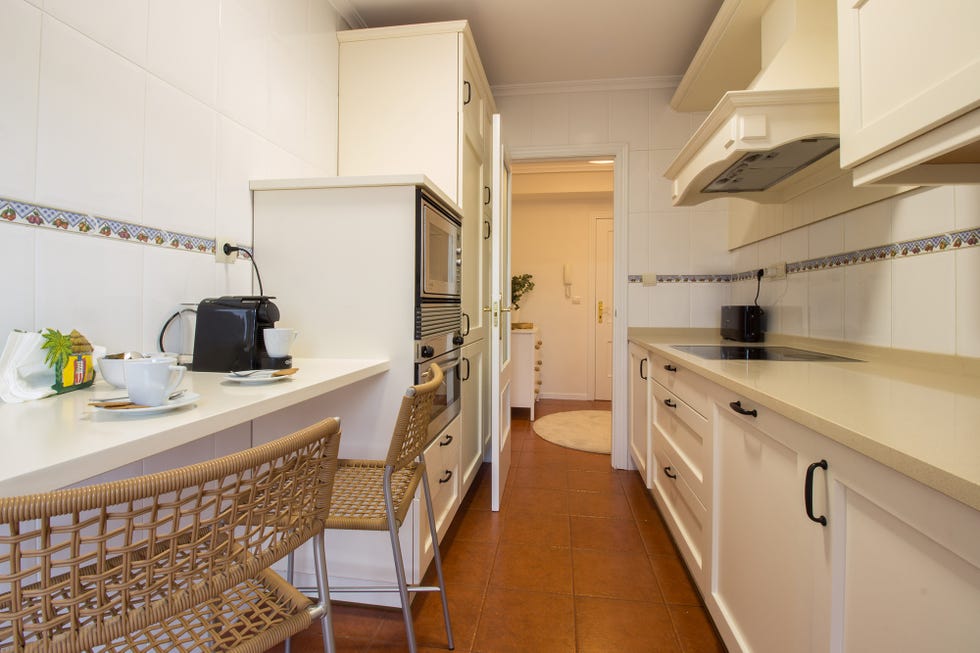 cocina moderna de color blanco con barra de desayunos