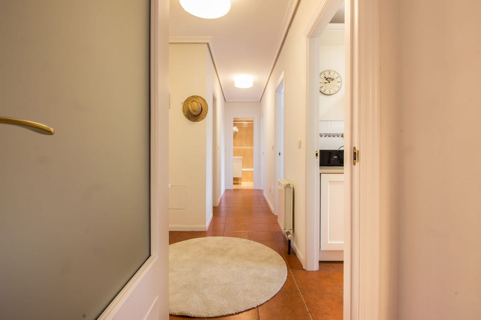 pasillo distribuidor pintado de blanco con decoración de estilo nórdico