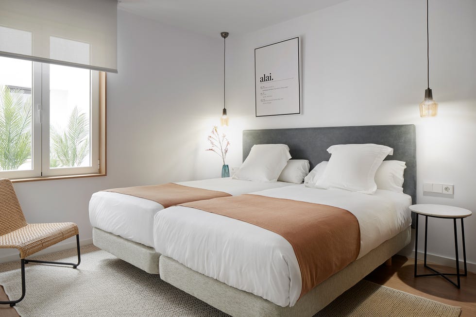 dormitorio con dos camas y cabecero gris
