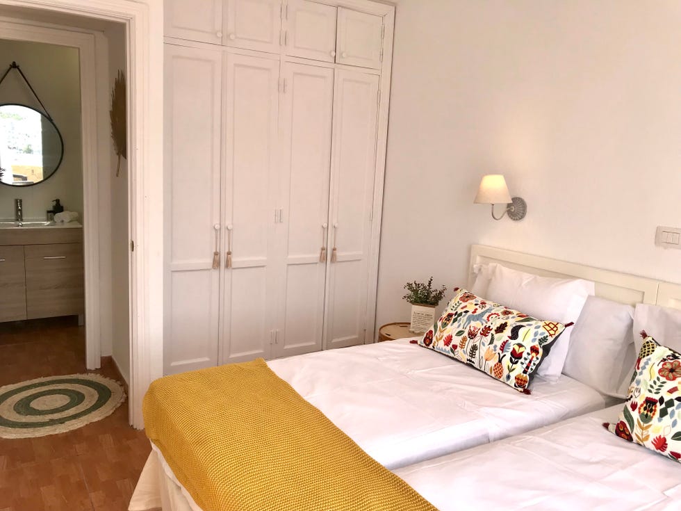 dormitorio con dos camas, armario empotrado y baño en suite
