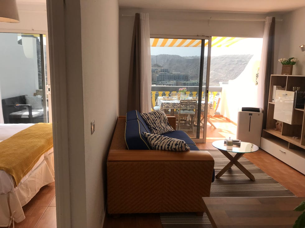 salón con sofá de fibras y tapizado azul y acceso a la terraza