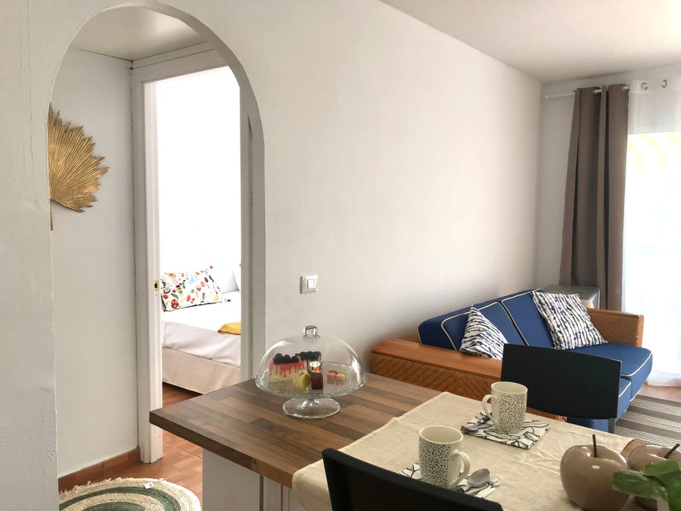 salón comedor con sofá azul y acceso a la terraza