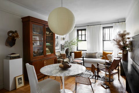 david frazier nyc apartment living room with limited space in this new york city apartment, designer david frazier divided the living room into two distinct zones lounging and eating paint simply white, benjamin moore dining table eero saarinen, knoll chairs lee industries slipper vintage french rattan vintage kaare klint safari pendant isamu noguchi bookcase scott antique markets ram’s head vintage, high point market