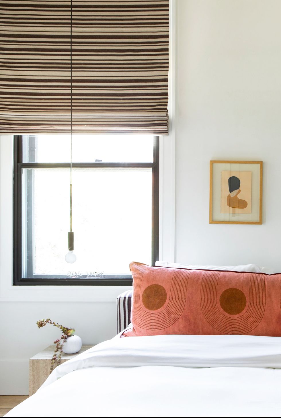 bedroom with orange pillow and window