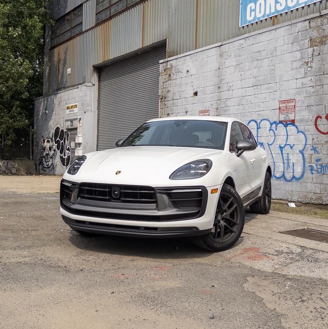 a white car parked in front of a building with graffiti