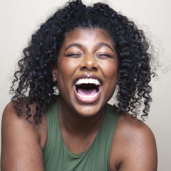 young beautiful black woman smiling against white background