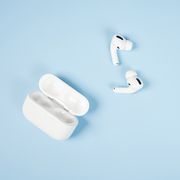 a pair of airpods and case against a blue background