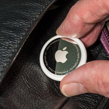 apple airtag being inserted into a leather compartment