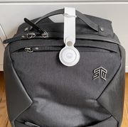 apple airtag strapped to handle of black bag