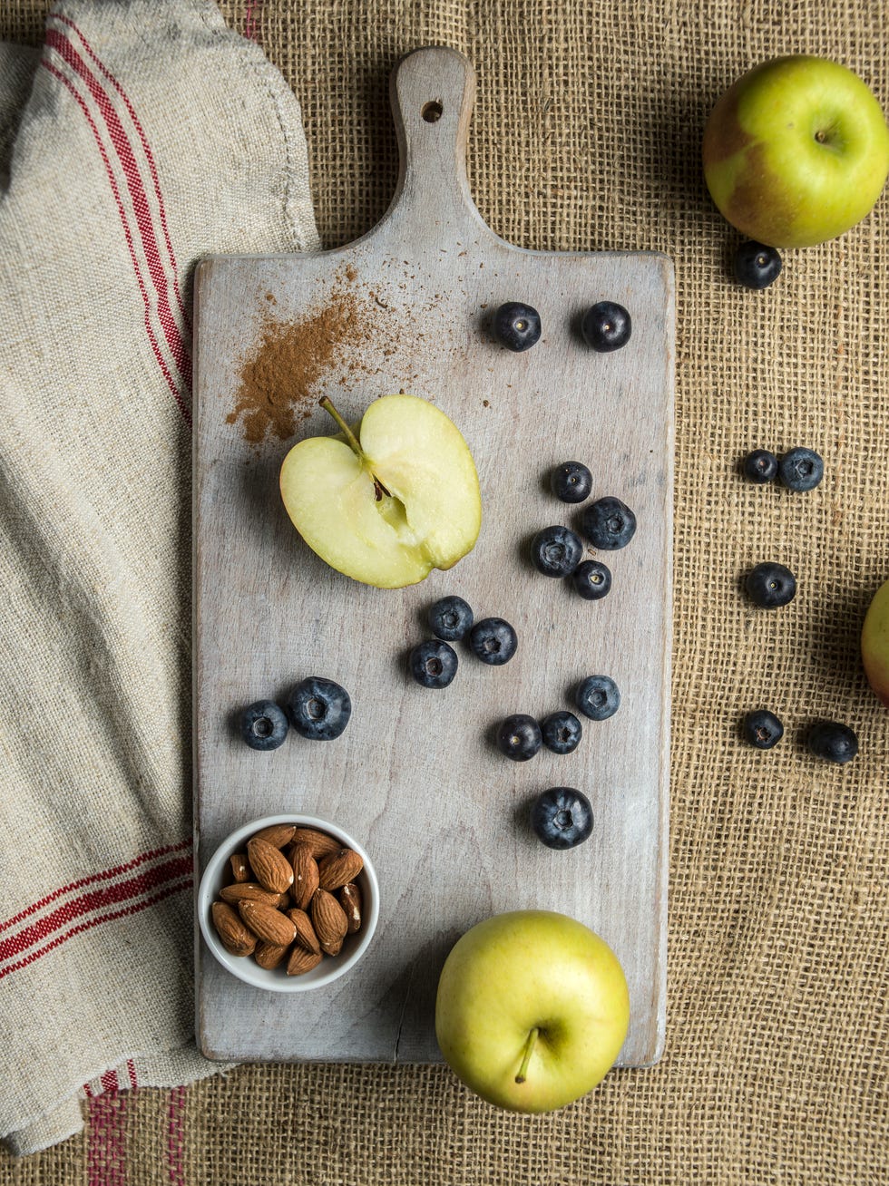 apple, blueberries and almonds on chopping board, overhead view