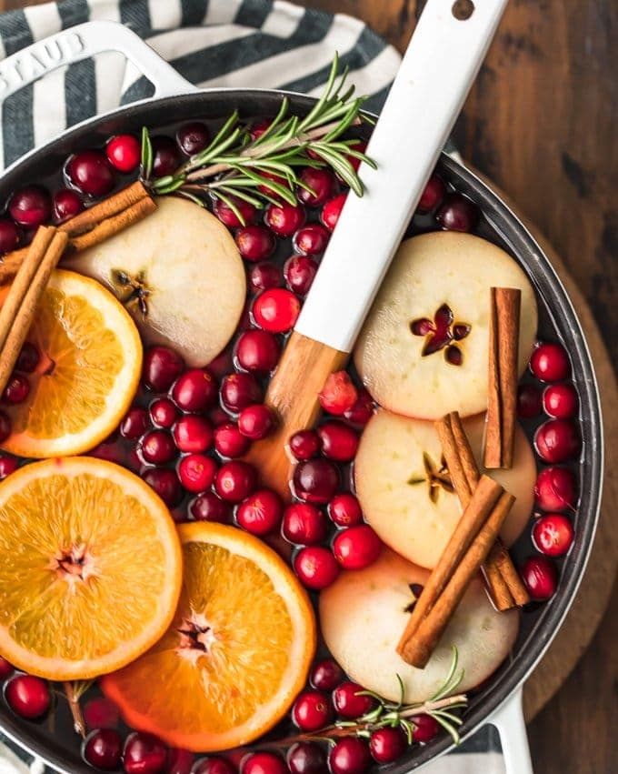 hot cranberry apple cider in pot with orange slices and cinnamon sticks