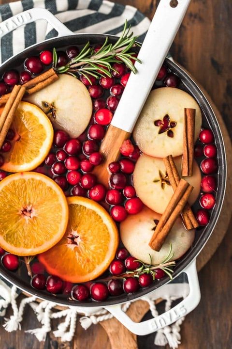 hot cranberry apple cider in pot with orange slices and cinnamon sticks