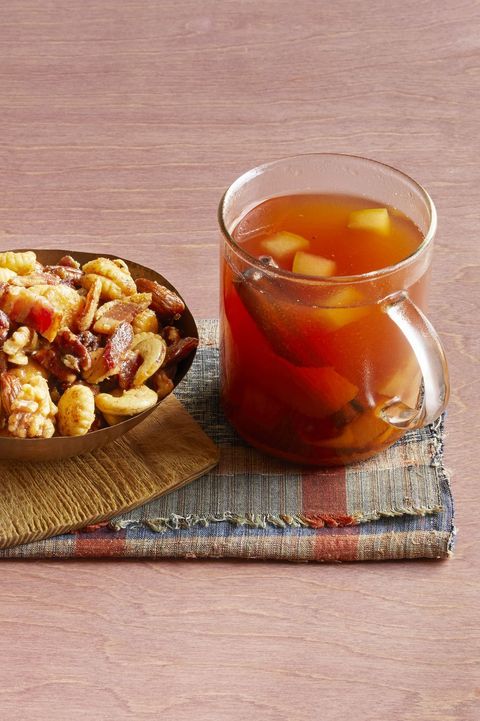 mulled cider with bourbon in glass mug with nuts on the side