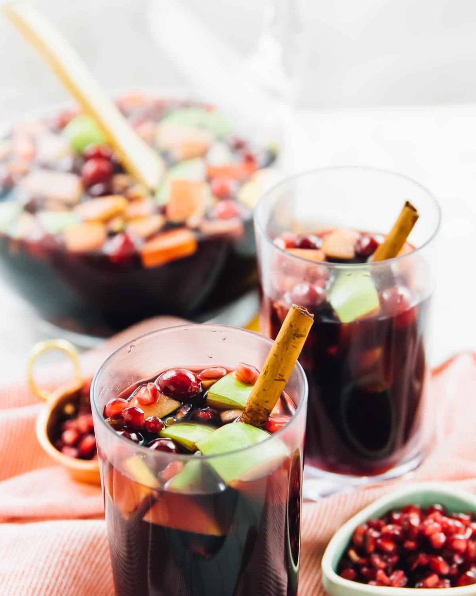 red wine apple cider fall sangria in glasses with pomegranate seeds on side