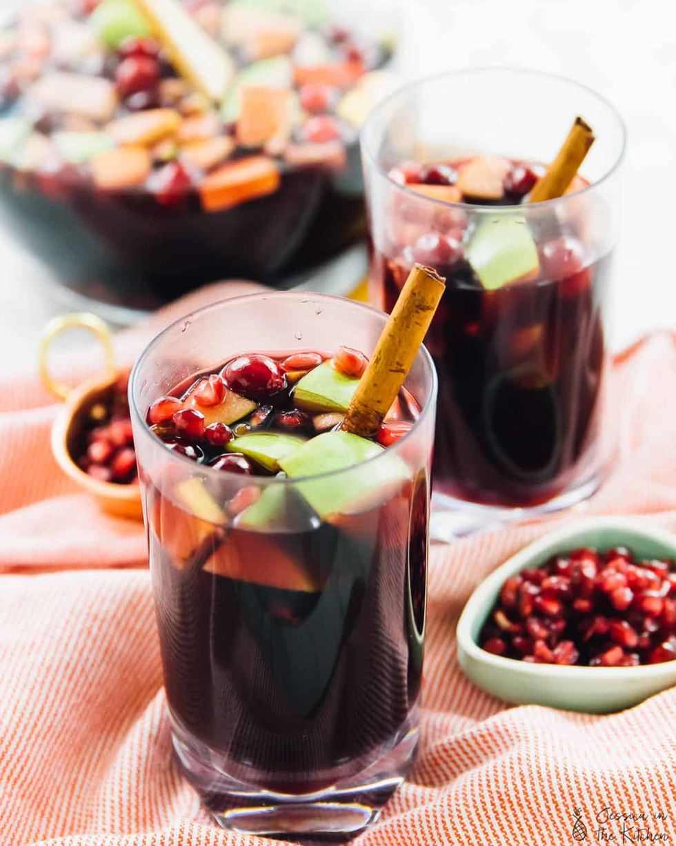 red wine apple cider fall sangria in glasses with pomegranate seeds on side
