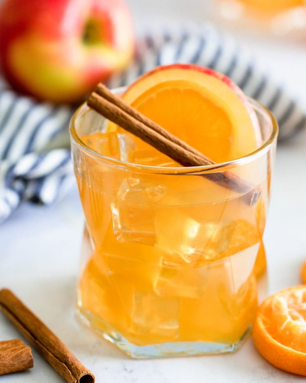 sparkling apple cider rum punch in glass with cinnamon stick